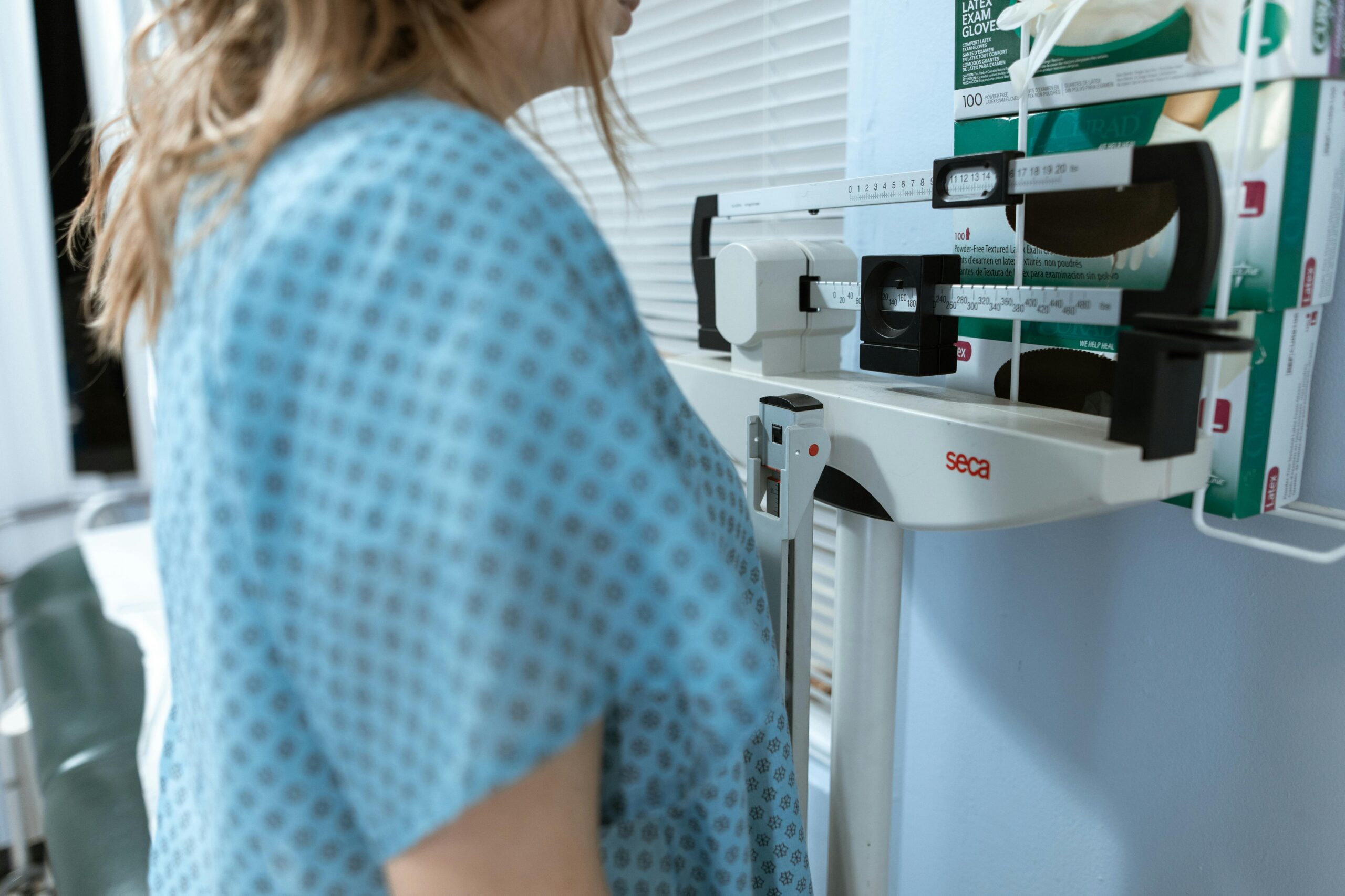 Client standing on scales in medical setting